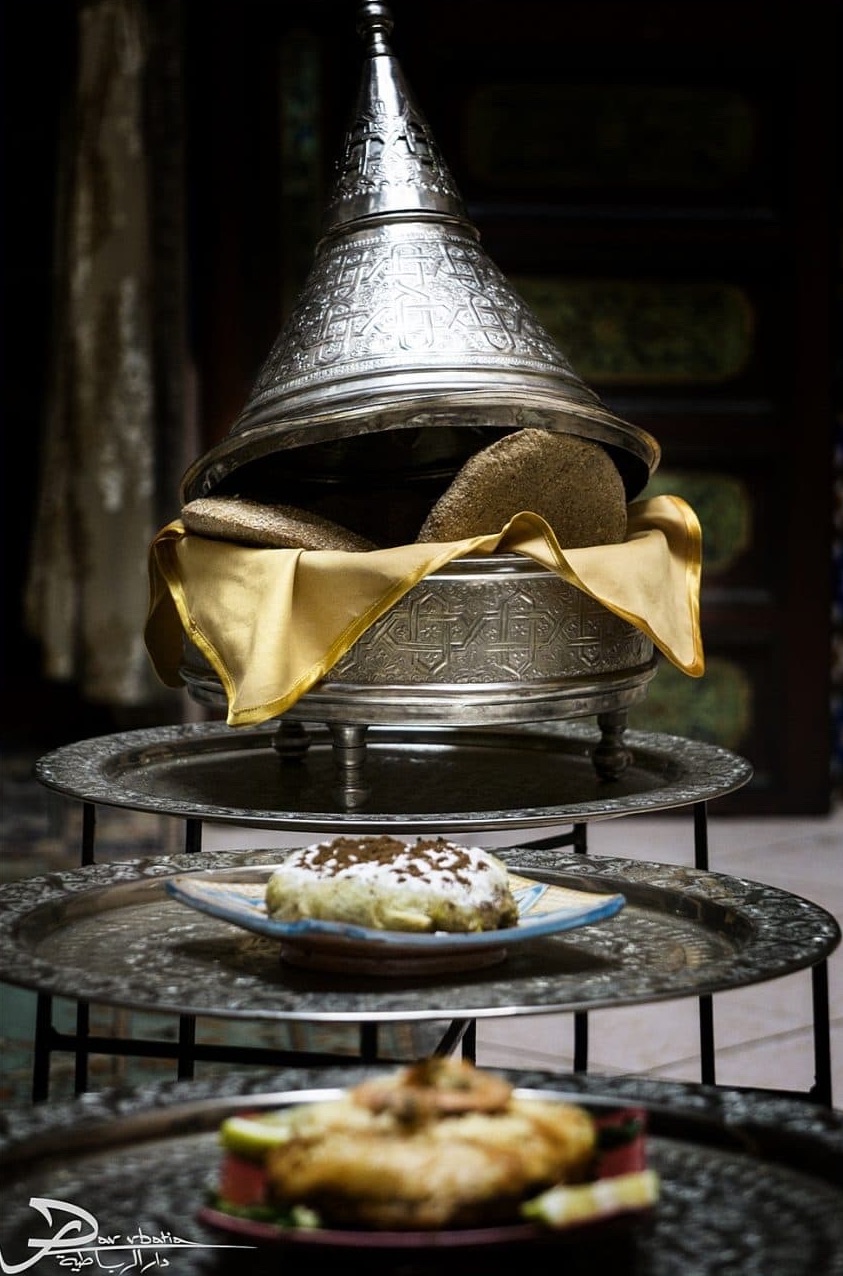 Service à la marocaine : panière conique en argent ciselé garnie de pain, pastilla au lait et pastilla sur plateaux